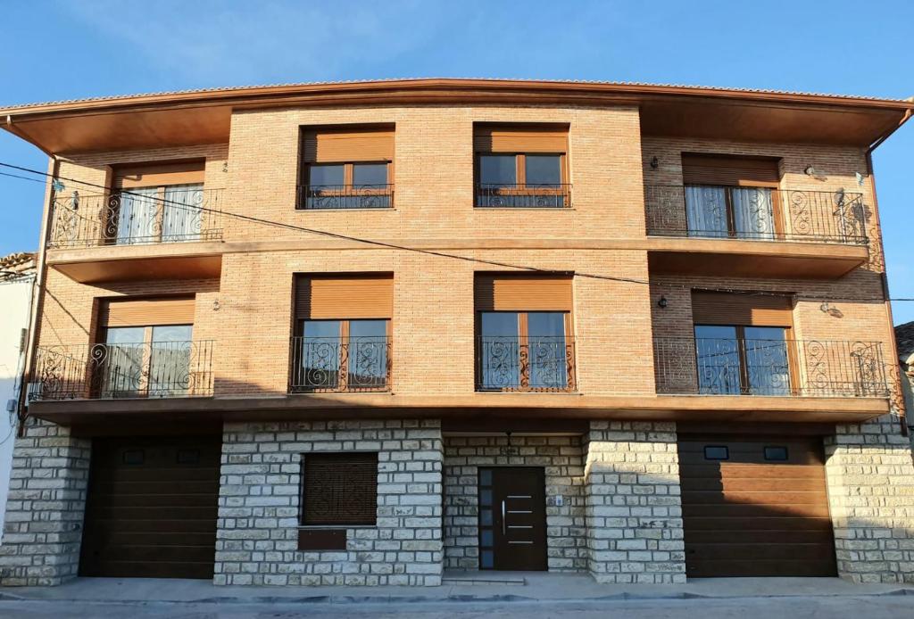 MonegrilloAmanece Monegrillo Apartamentos的棕色砖砌的建筑,设有窗户和阳台