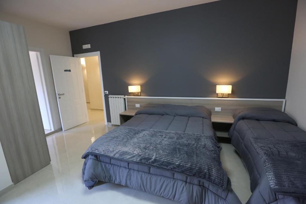 那不勒斯COSTA APARTMENT NAPLES的一间卧室配有两张床,墙上有两盏灯
