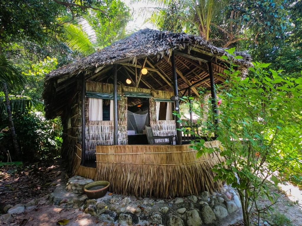 诗巫岛Rimba Resort - Dive Centre & Spa的茅草屋顶的小房子