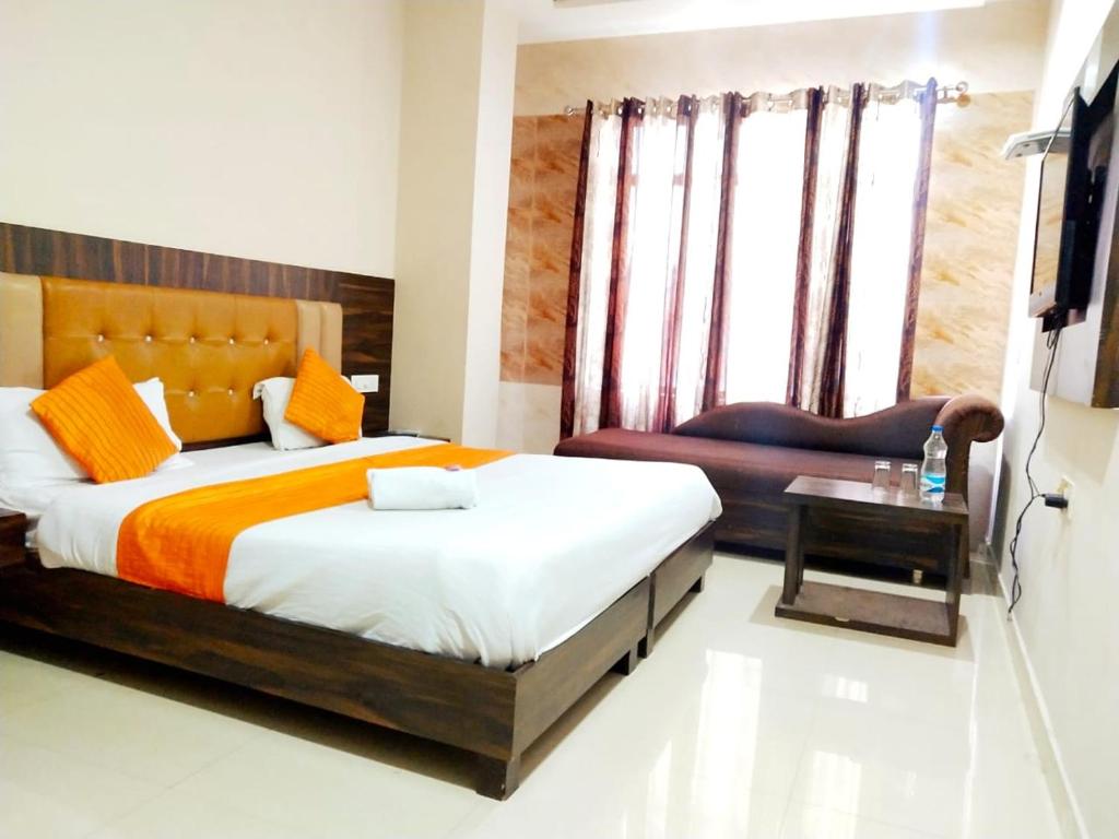 阿姆利则Hotel Sukhman Residency的一间卧室配有一张大床和一把椅子