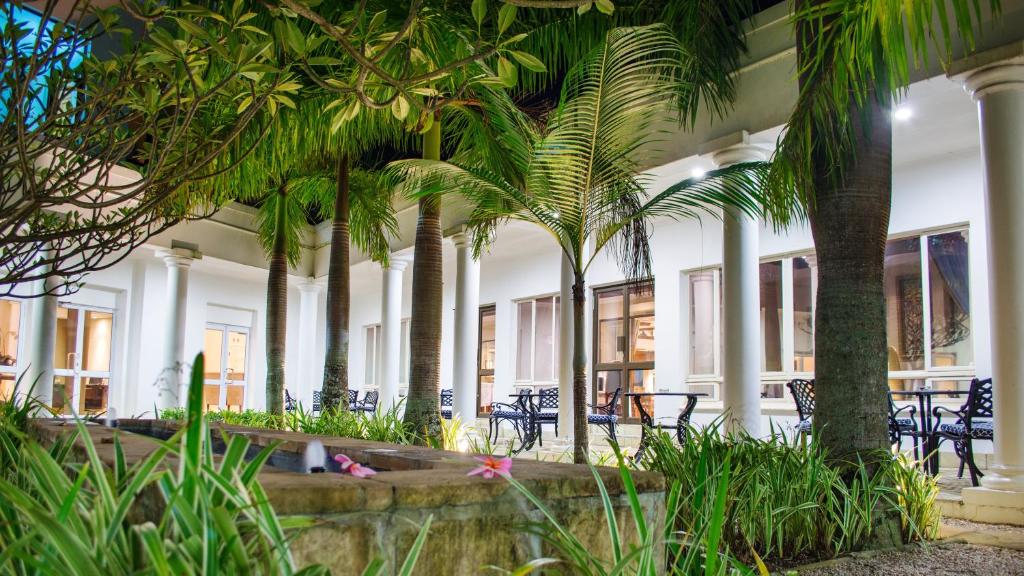 理查兹湾理查兹尊贵酒店的一座棕榈树、桌椅的建筑