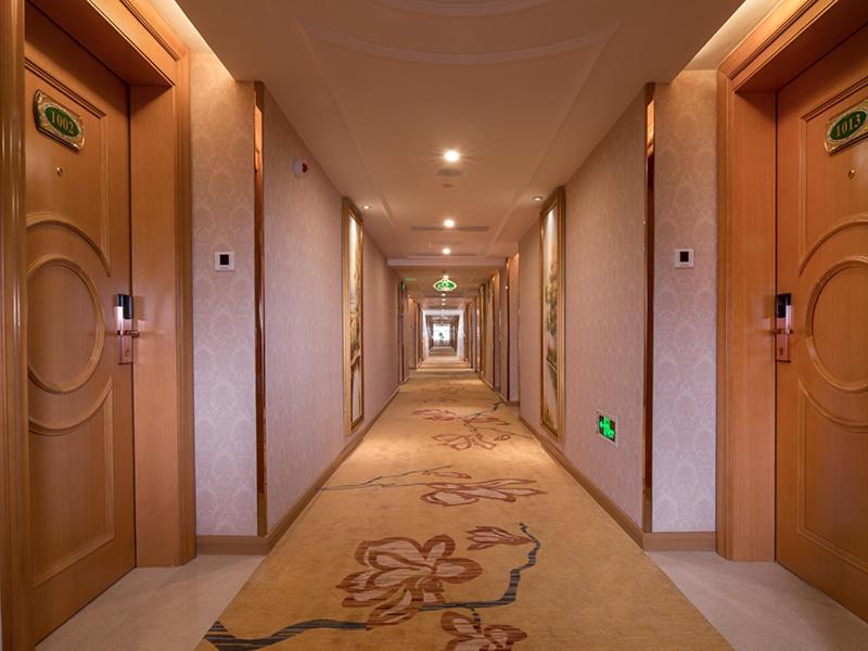 Fenghuangwei维也纳国际酒店 (深圳福永会展中心店)的一条空走廊,走廊长为一横横横的长度