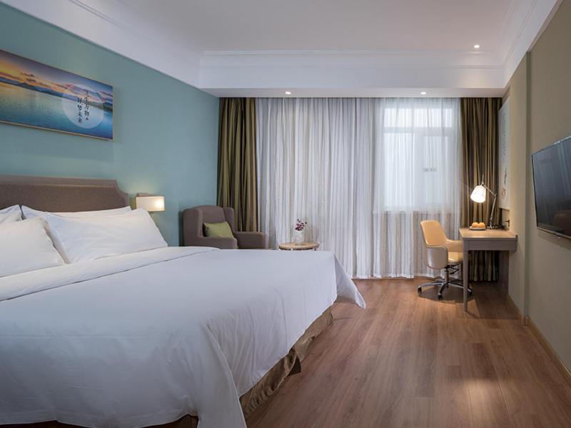 澄迈维也纳3好酒店 (海口澄迈老城店)的酒店客房设有一张大床和一张书桌。