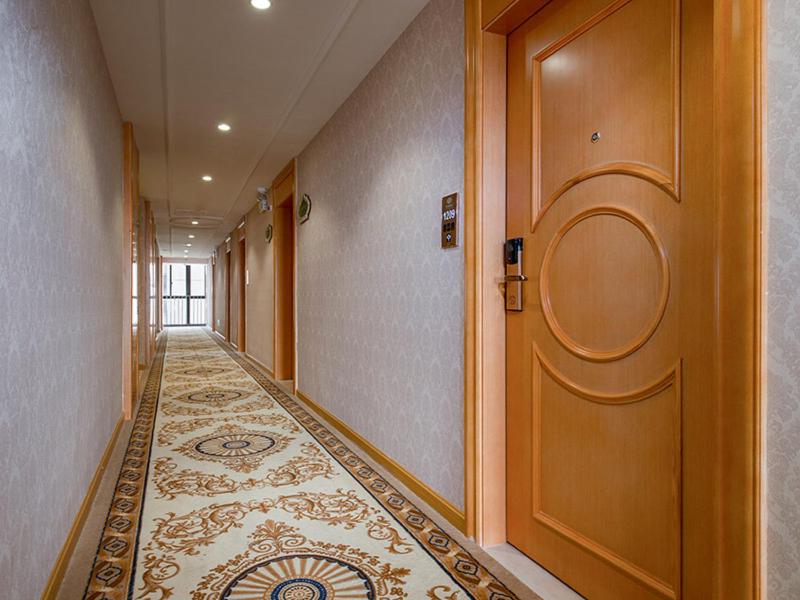 福州维也纳酒店 (福州长乐国际机场店)的走廊设有大型木门,铺有瓷砖地板