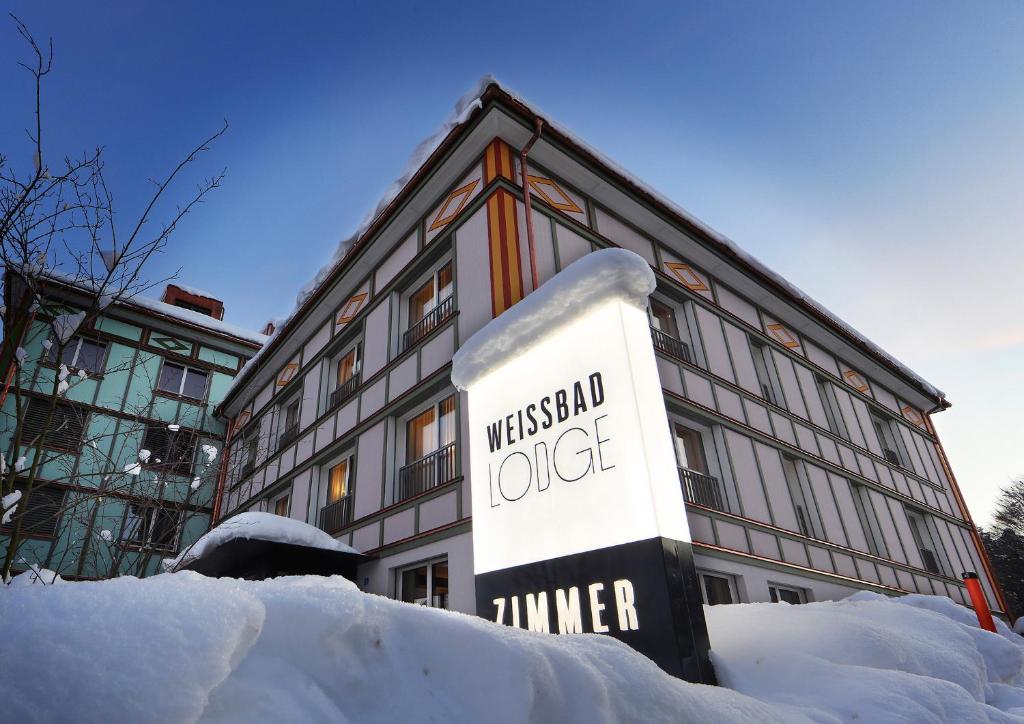 韦斯巴德Weissbad Lodge的建筑物前雪中的标志