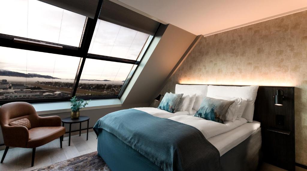 特隆赫姆盘拉玛品质酒店的一间卧室设有一张大床、一把椅子和窗户。