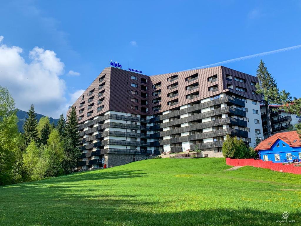 波亚纳布拉索夫Apartament Alpin resort etaj 7的绿色田野顶部的大建筑