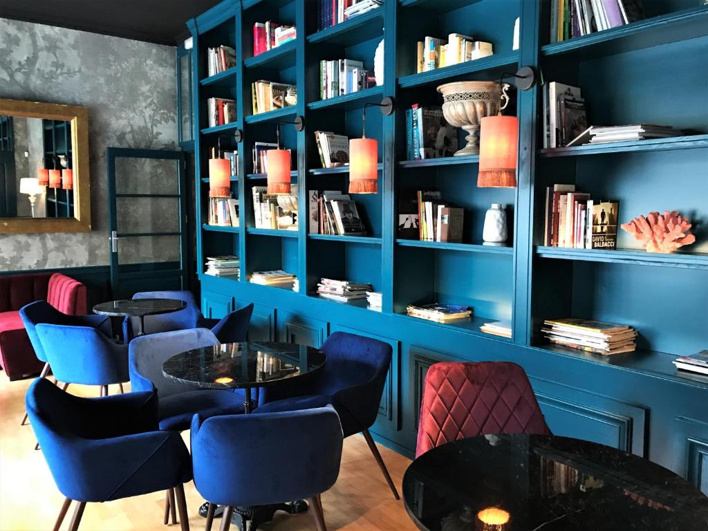 帕拉莫斯Hotel Vostra Llar的一间拥有蓝色墙壁、桌子和书架的房间