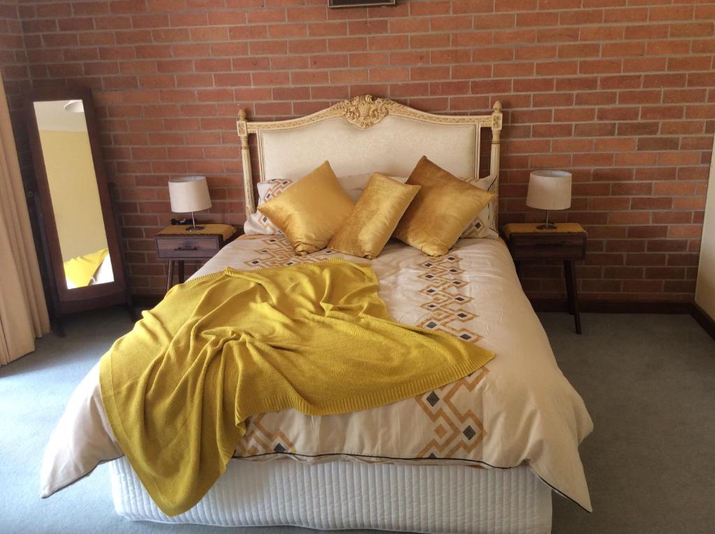 DunollyDunolly Broadway B&B的一间卧室配有一张带黄色床单和枕头的床。