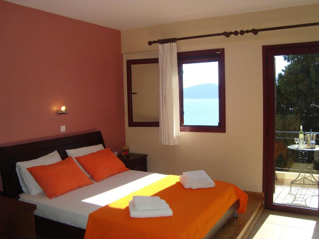 米克罗斯雅洛斯Mikros Gialos Apartments的一间卧室配有带橙色枕头的床和窗户。