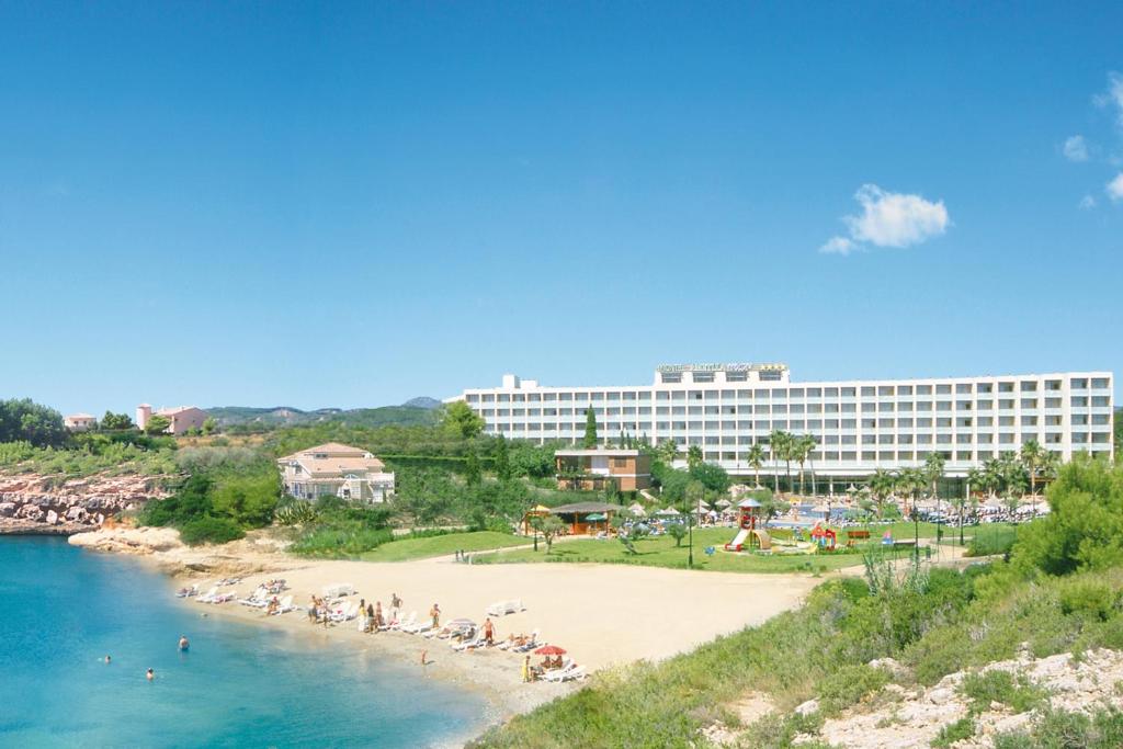 拉梅特拉·德·玛尔RVHotels Hotel Ametlla Mar的拥有海滩和大型建筑的度假胜地