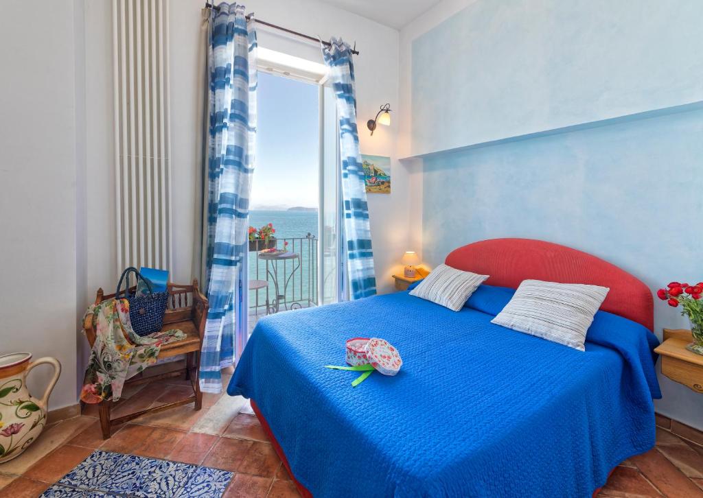 伊斯基亚利亚达别墅的一间卧室设有蓝色的床和窗户。