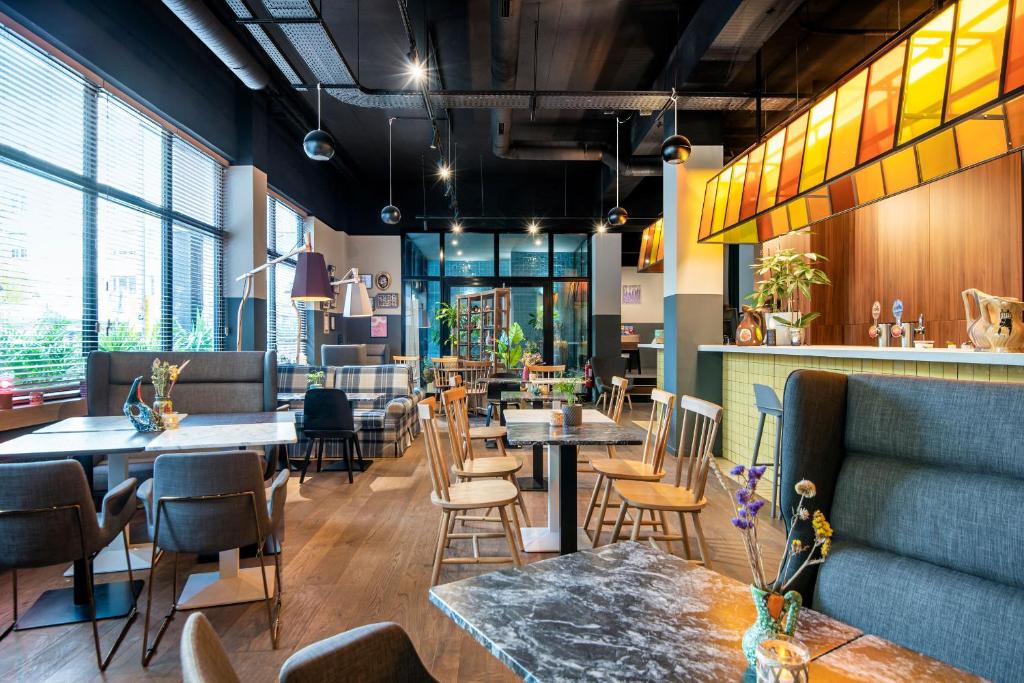 斯特拉斯堡Hotel Kaijoo by HappyCulture的一间带桌椅的餐厅和一间酒吧
