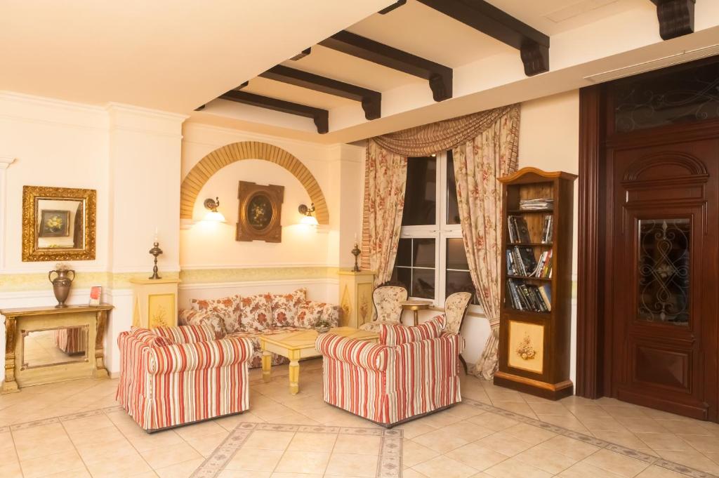 蒂米什瓦拉卡萨德拉罗萨酒店的客厅配有两把椅子和一张沙发