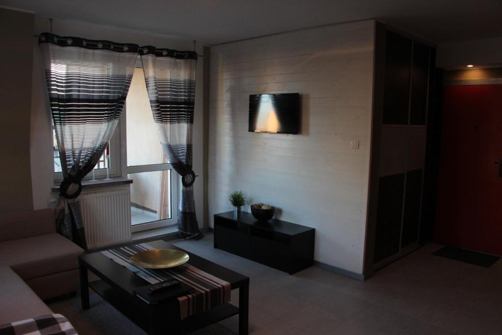 比得哥什雅盖隆公寓70号的客厅配有桌子和2扇窗户