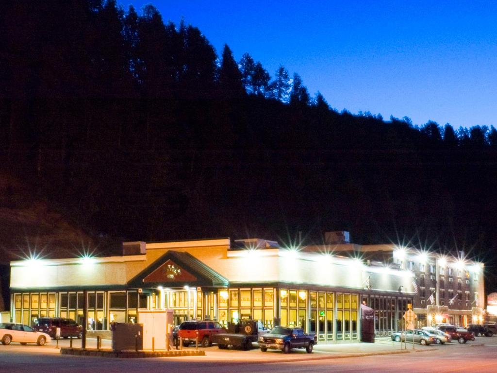 戴德伍德First Gold Gaming Resort的一座有汽车在晚上停在停车场的建筑