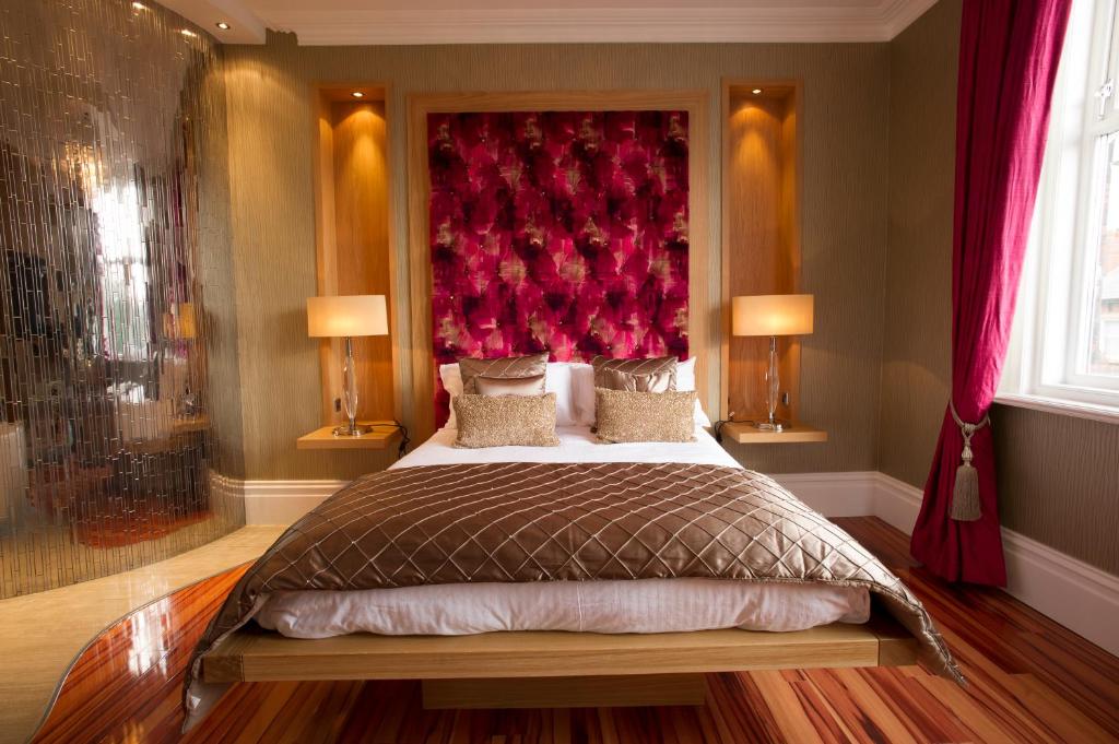 波尔顿乐法尔德布雷克公寓酒店的一间卧室配有一张大床和红色床头板