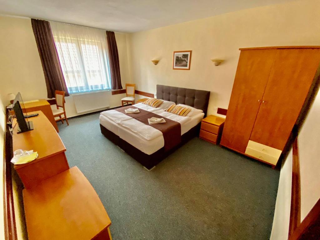 波普拉德塔特拉蒙蒂酒店的配有一张床和一张书桌的酒店客房