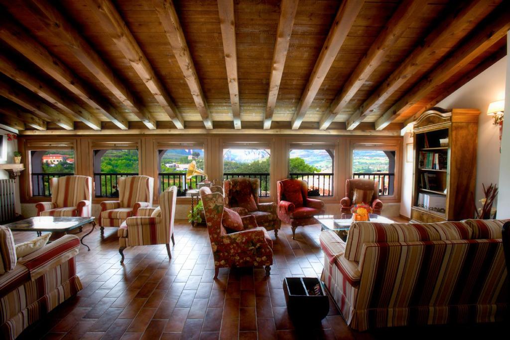 NaldaCasa Rural Torredano的带沙发、桌子和窗户的大型客厅