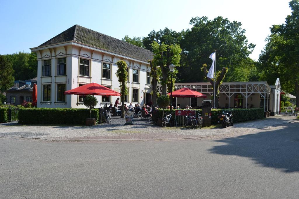 默伊德贝赫右居餐厅酒店的前面有桌子和红伞的建筑