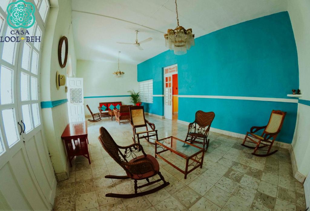 梅里达Casa Lool Beh的一间设有椅子和蓝色墙壁的房间