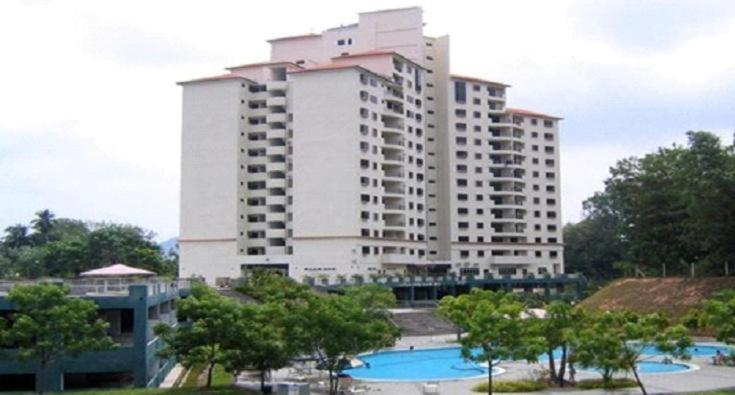 卢穆特Lumut Valley Condominium的一座白色的大建筑,前面设有一个游泳池