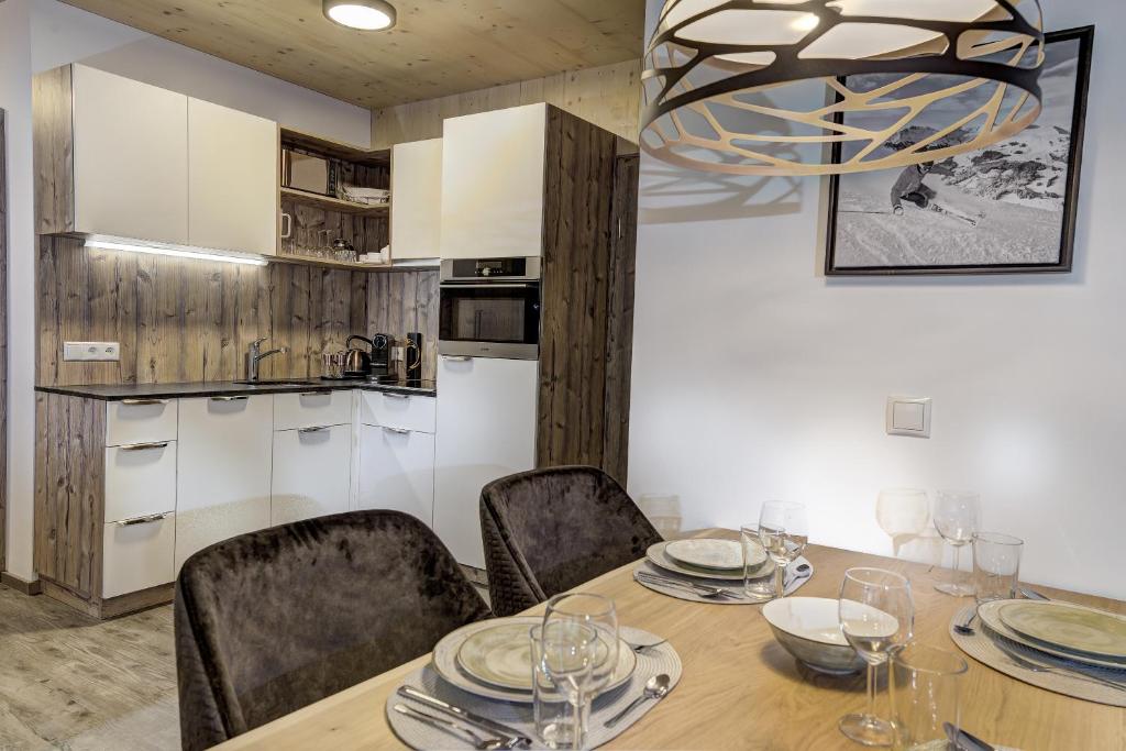 罗孚尔Herbst Wohnerlebnis的厨房以及带桌椅的用餐室。