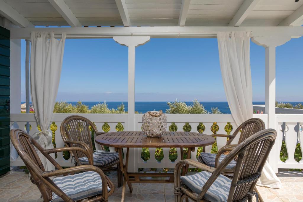 圣尼古拉奥斯Kostas Cottages的海景门廊上的桌椅