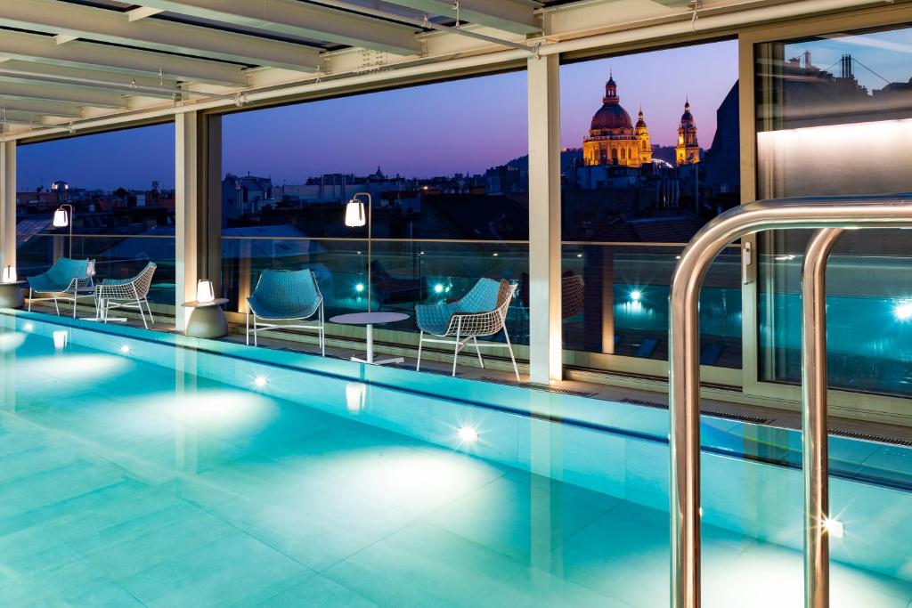 布达佩斯Cortile Hotel - Adults Only的酒店游泳池享有城市美景