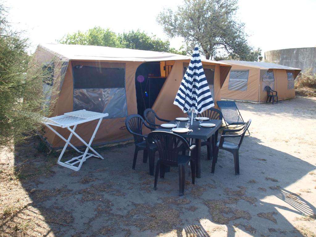 圣马迪拉莫Oh! Campings La Brise的配有桌椅和旗帜的帐篷
