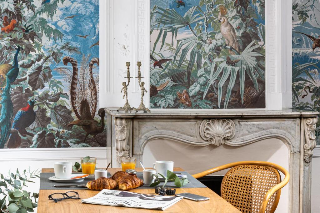 普罗旺斯艾克斯道芬住宿加早餐旅馆的一间带桌子和壁画的用餐室
