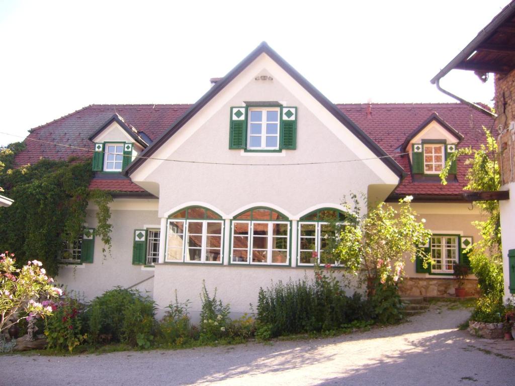 格拉茨希思恩霍夫酒店的一座白色的大房子,上面有绿色百叶窗