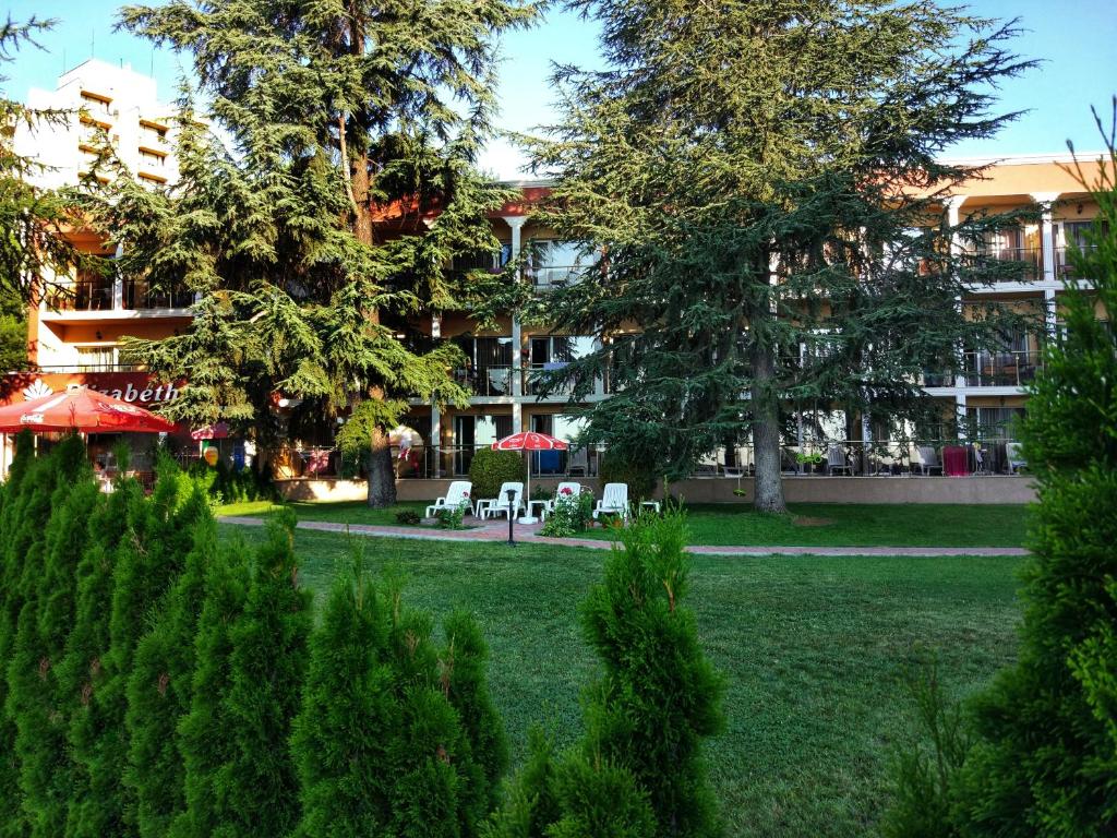 内塞伯尔Elizabeth Dy Boutique Hotel的一座公园,在一座建筑前,有椅子和树木