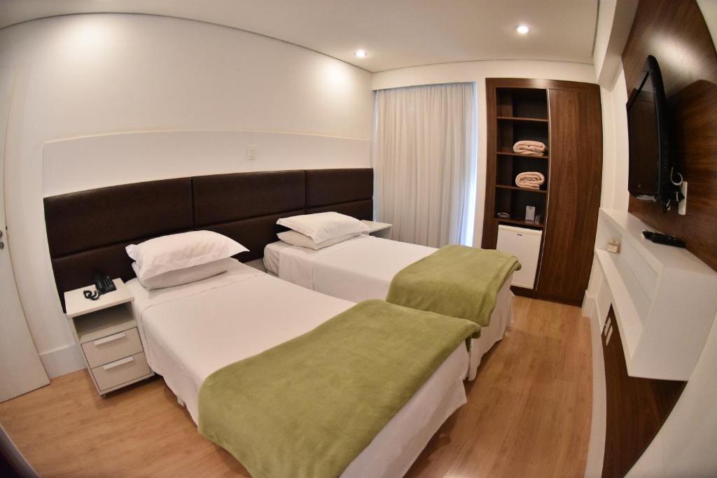 塞拉内格拉Cordilheira Hotel的酒店客房设有两张床和电视。