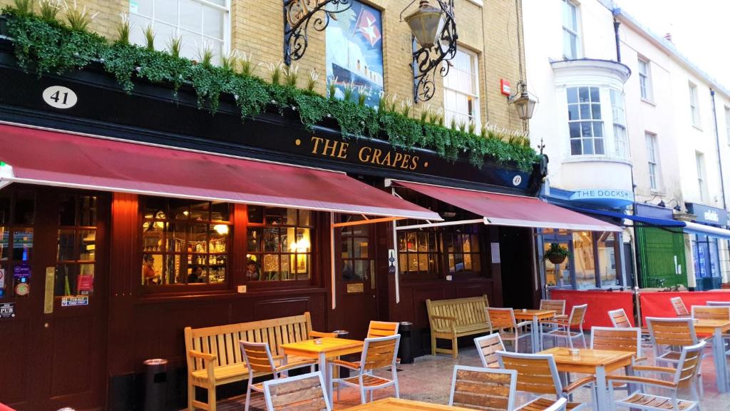 南安普敦The Grapes Pub的大楼前设有桌椅的餐厅