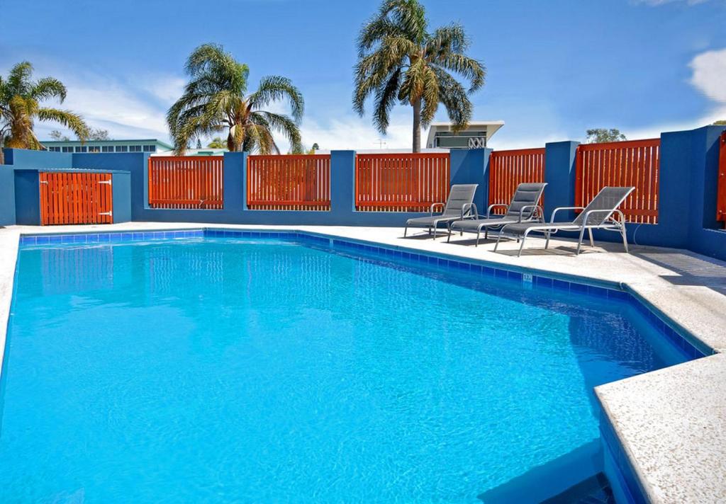 麦夸里港东港汽车旅馆的一个带椅子和围栏的蓝色游泳池