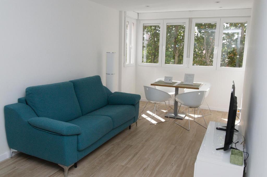 马德里Moderno,tranquilo, entrada autónoma y fácil aparcamiento.的客厅配有蓝色的沙发和桌子