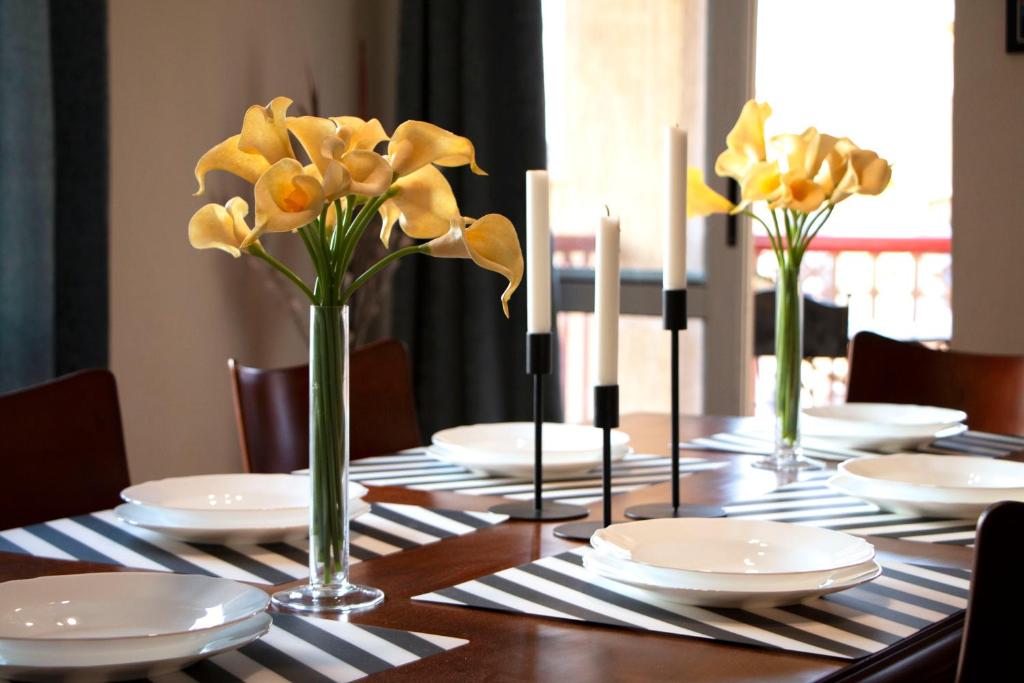 开罗Elegant home in Madinaty compound的花瓶里装有白色板子和黄色花的桌子