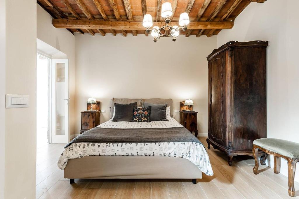 卢卡Cortile in centro - Charm Suite Heart of Lucca的一间卧室设有一张大床和木制天花板