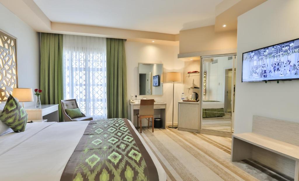 麦地那Le Bosphorus Al Madinah的酒店客房设有一张大床和平面电视