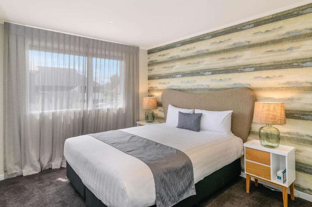 罗托鲁瓦Lakes Lodge Rotorua的一间卧室设有一张大床和一个大窗户