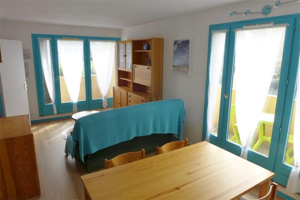 塞尼奥斯Réf 546, Seignosse océan , Appartement classé 2 étoiles , plage et centre à 5mn, 5 personnes的客厅配有木桌和窗户。