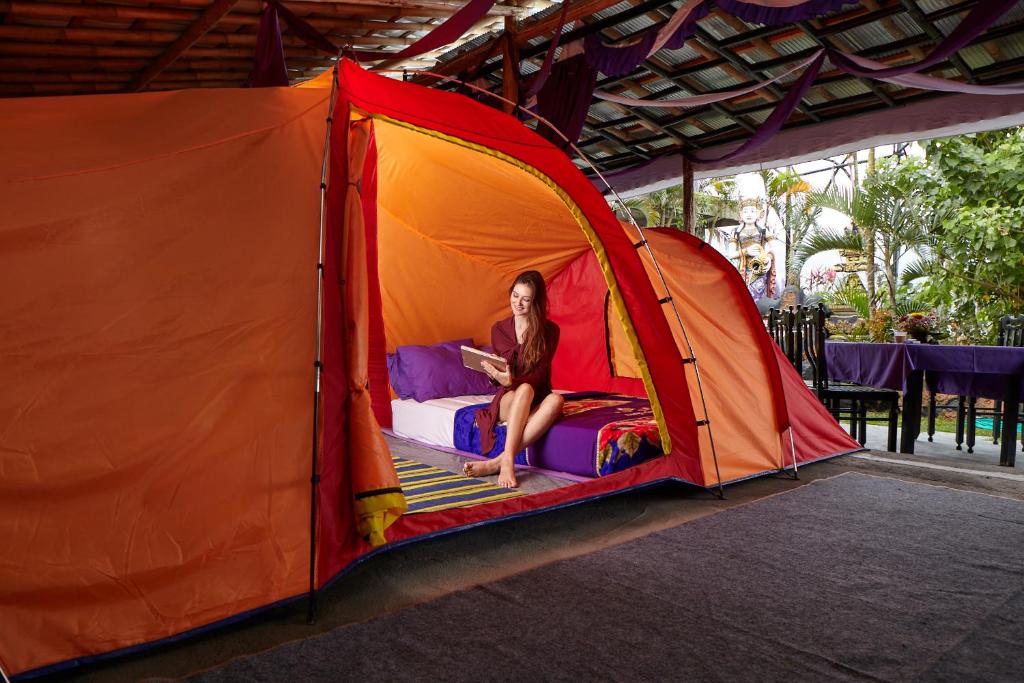 金塔马尼Hiker's Camp at Toya Devasya的坐在帐篷里的床上的女人