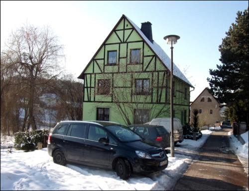 Kohren-SahlisFerienwohnung Kohrener Land的停在绿色房子前面的一辆黑色货车