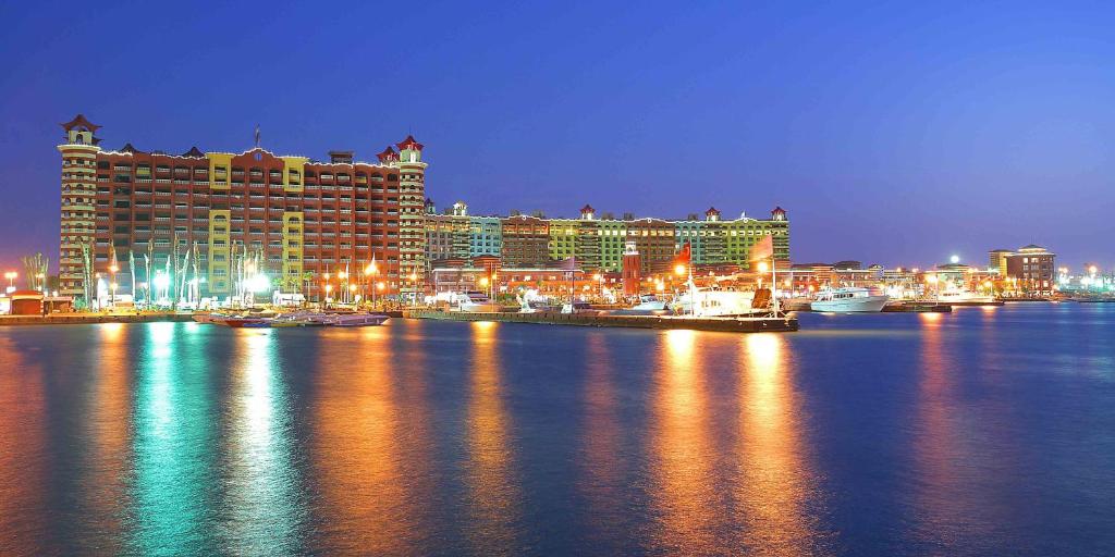 阿莱曼Porto Marina Apartments By Amer-Group的晚上可欣赏到酒店和城市的景色