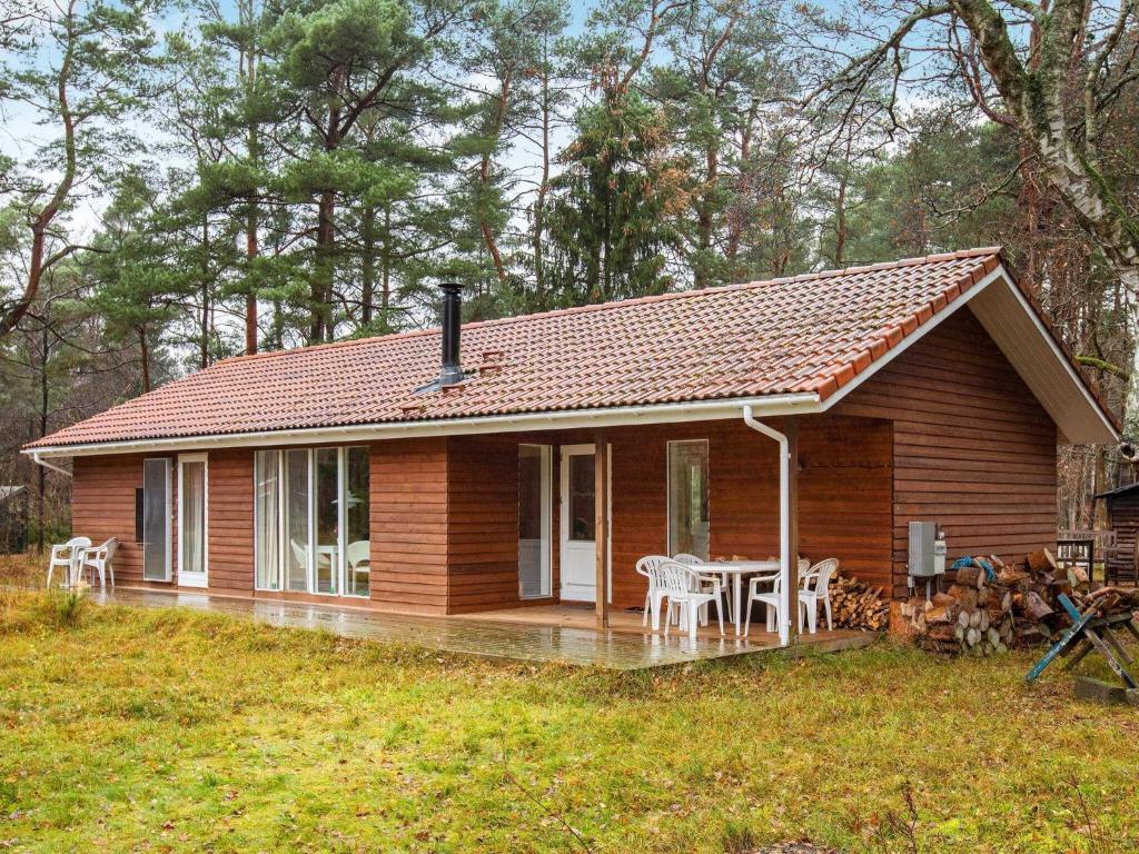 弗雷德里克斯伐克8 person holiday home in Frederiksv rk的一座配有桌椅的小木房子