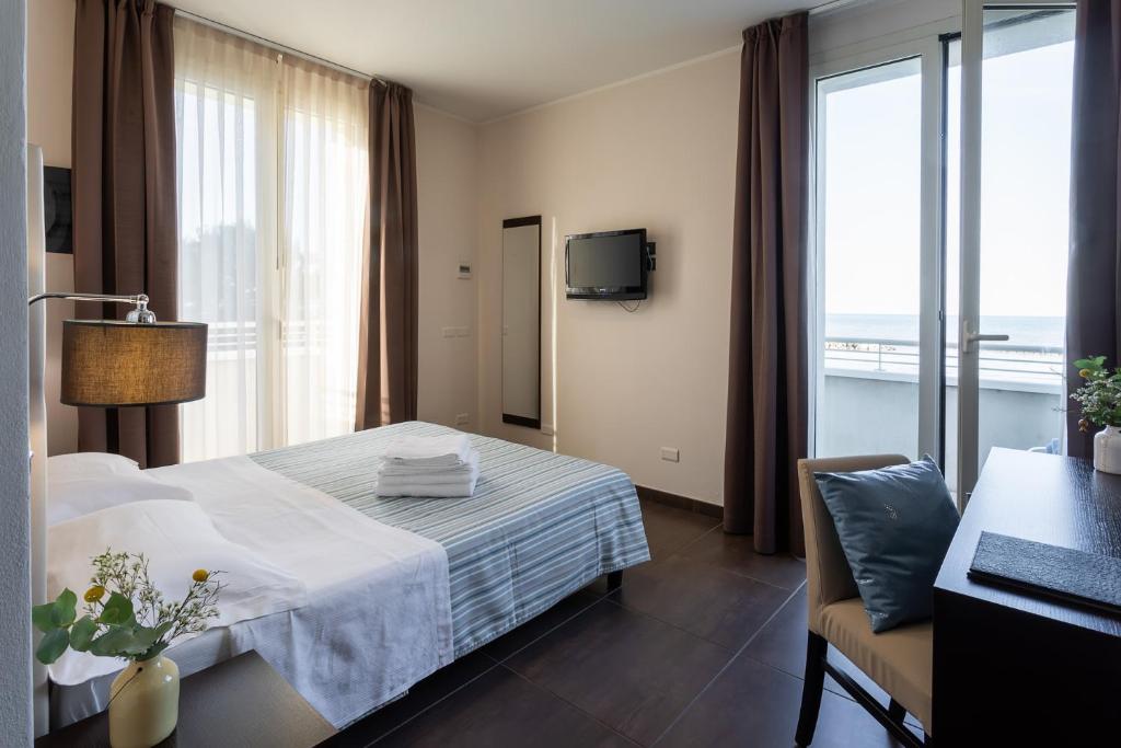 里米尼格米酒店的酒店客房设有床和窗户。
