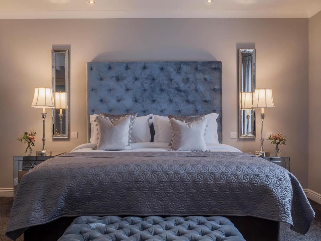 特拉利阿什酒店的一间卧室配有一张大床和蓝色床头板