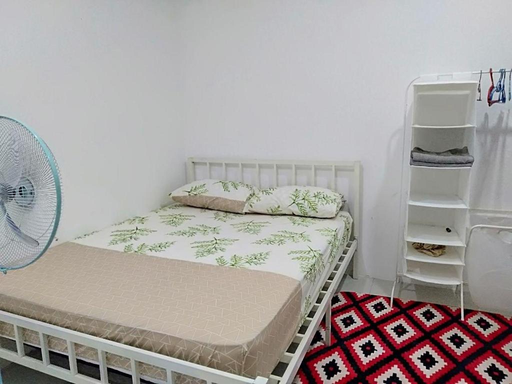 Tanjung KarangSri Manik Guest House Tanjung Karang的一间带一张床和风扇的小卧室