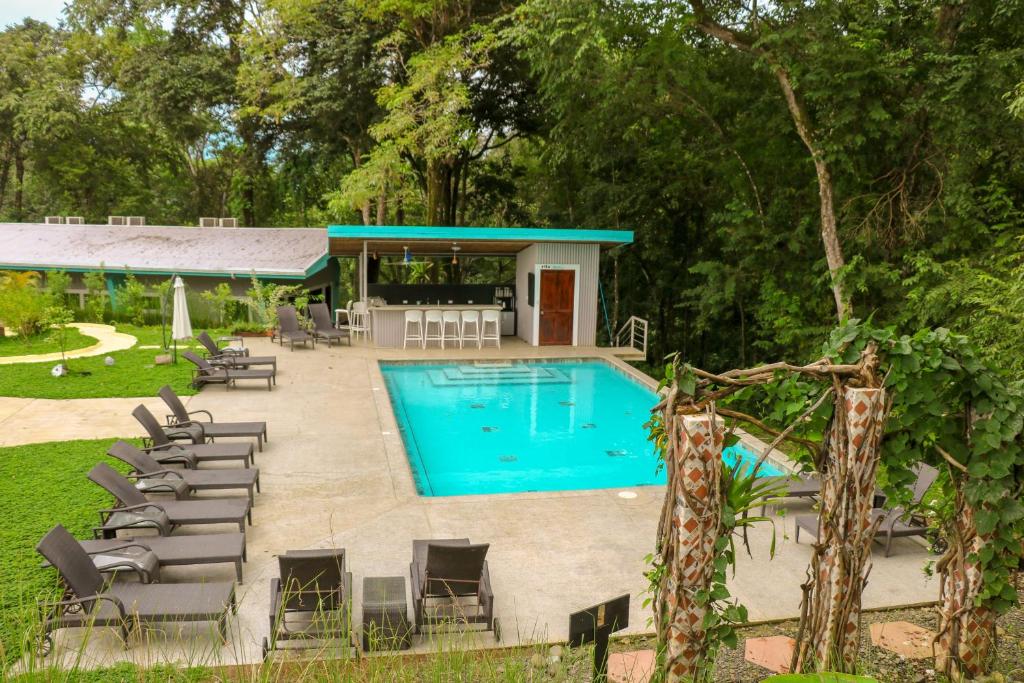 曼努埃尔安东尼奥Teva Hotel & Jungle Reserve的一个带椅子的游泳池以及一座房子